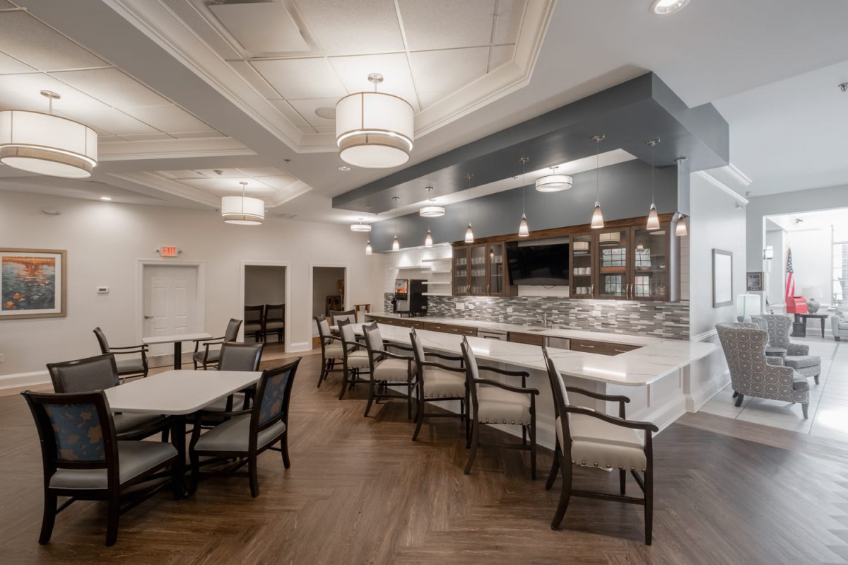 A contemporary kitchen and dining area with bar seating, modern lighting fixtures, and elegant decor.