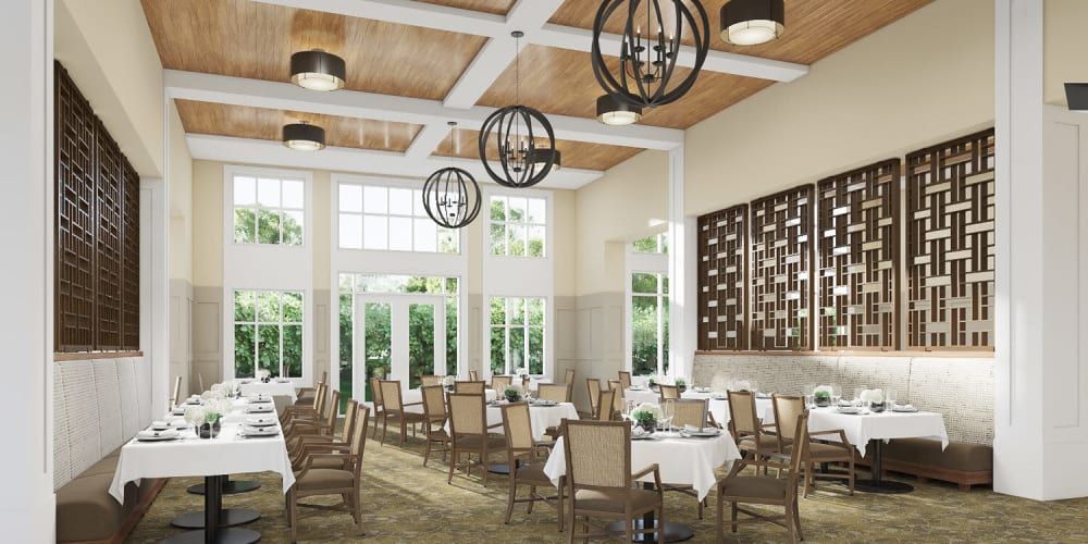 A spacious and elegantly designed restaurant dining area with large windows and stylish chandeliers.