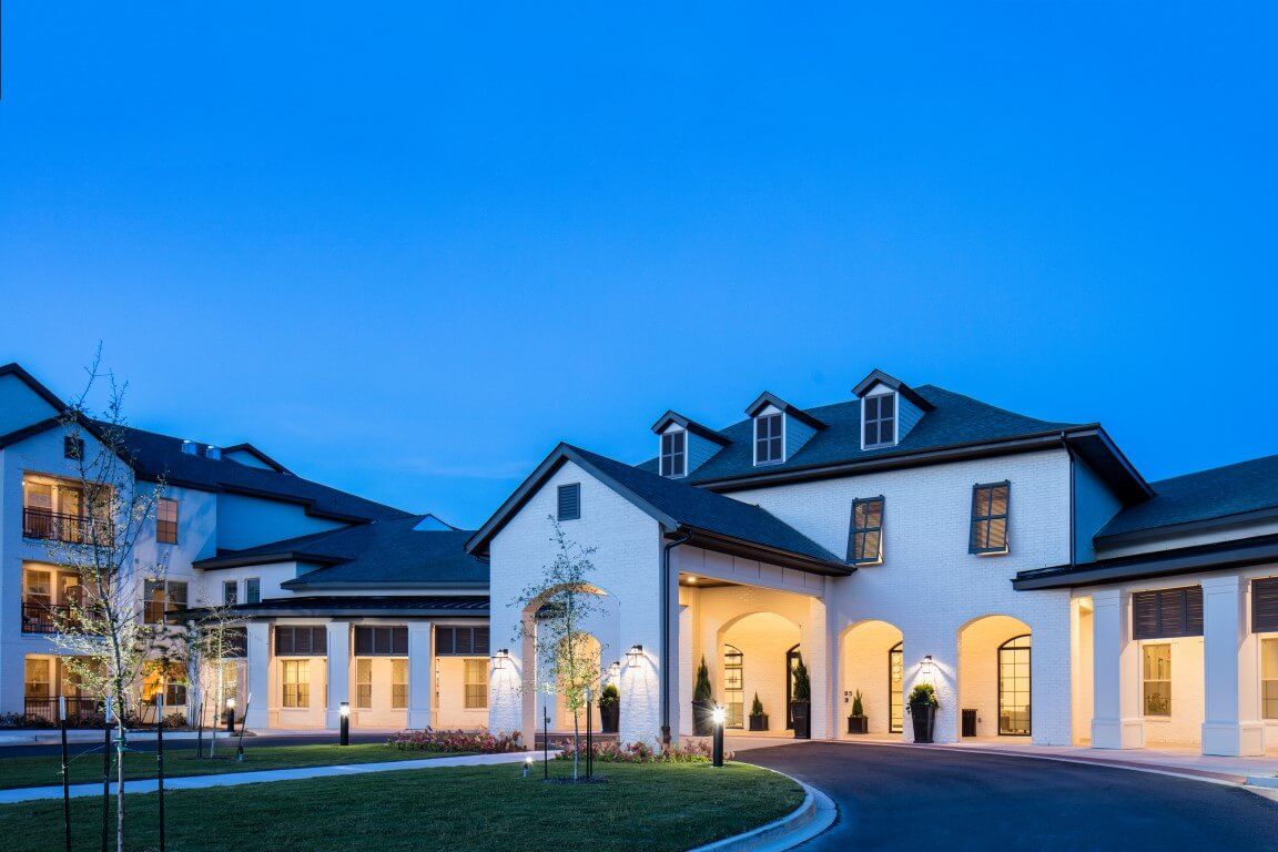 A beautifully lit building at dusk with a clear blue sky.
