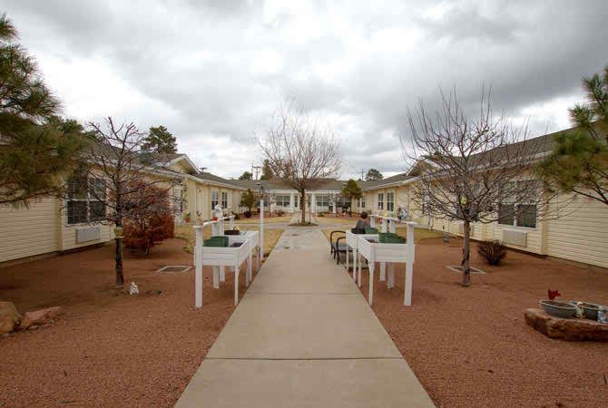 A peaceful courtyard with tables and chairs on a cloudy day.