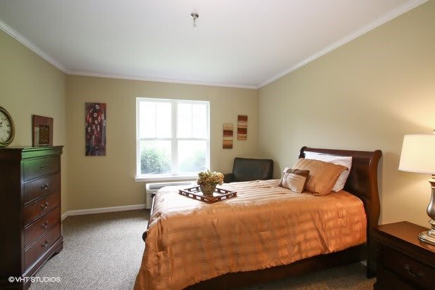 A cozy bedroom with a large bed, soft lighting, and tasteful decor.