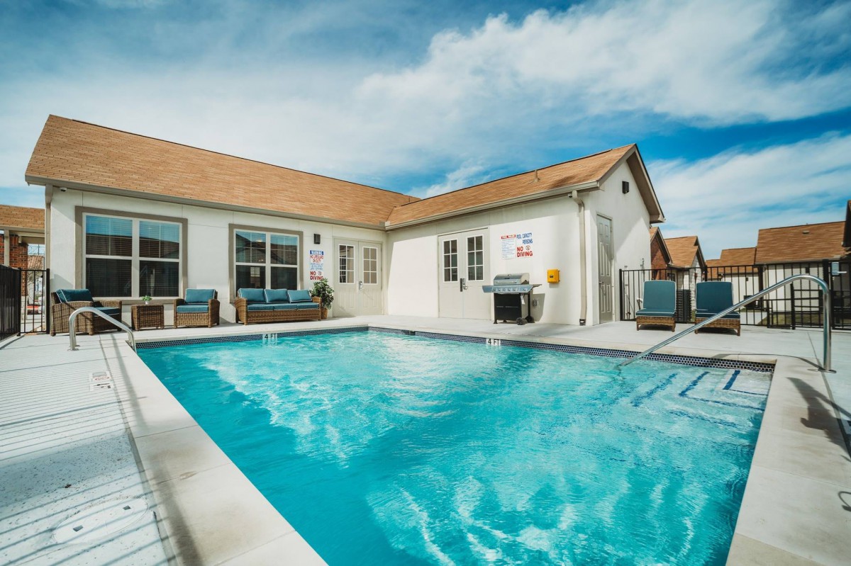 A sunny day in a residential backyard with a swimming pool.