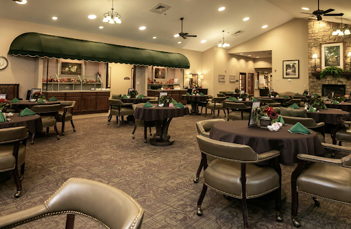 A well-arranged dining area featuring tables and chairs, illuminated by warm lighting.