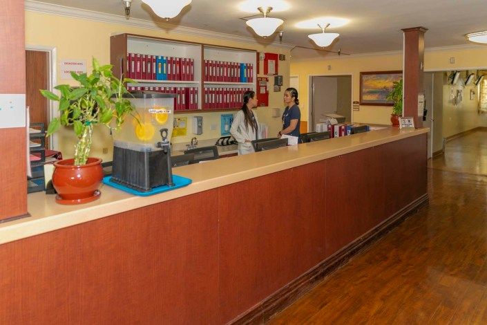 A reception desk area in an office with two people interacting.