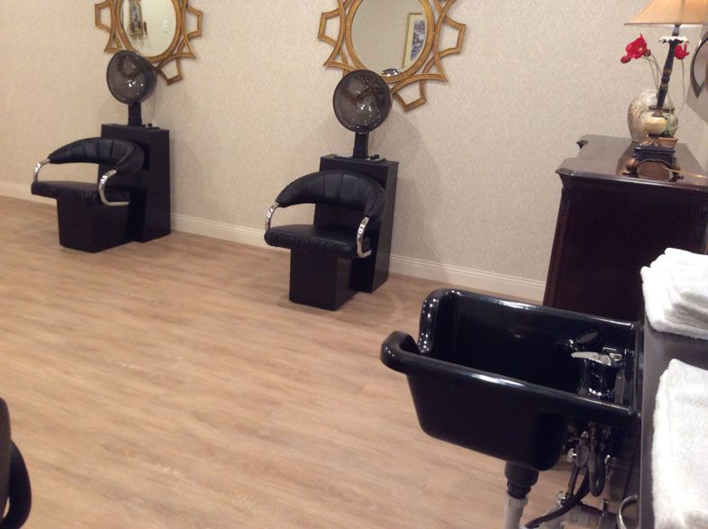 Interior of a hair salon with styling chairs, mirrors, and hair dryers.