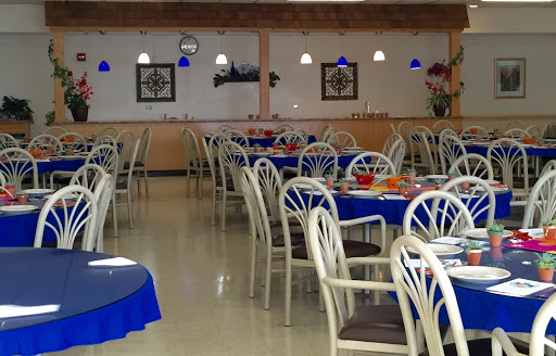A spacious restaurant interior featuring blue tablecloths and comfortable seating arrangements.