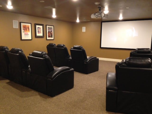 A cozy home theater room with comfortable seating and a large screen.