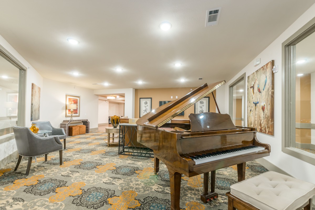 A cozy lounge featuring a grand piano and comfortable seating arrangements.