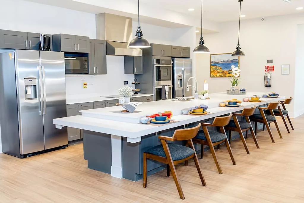 A modern kitchen featuring a large island with seating and sleek stainless steel appliances.