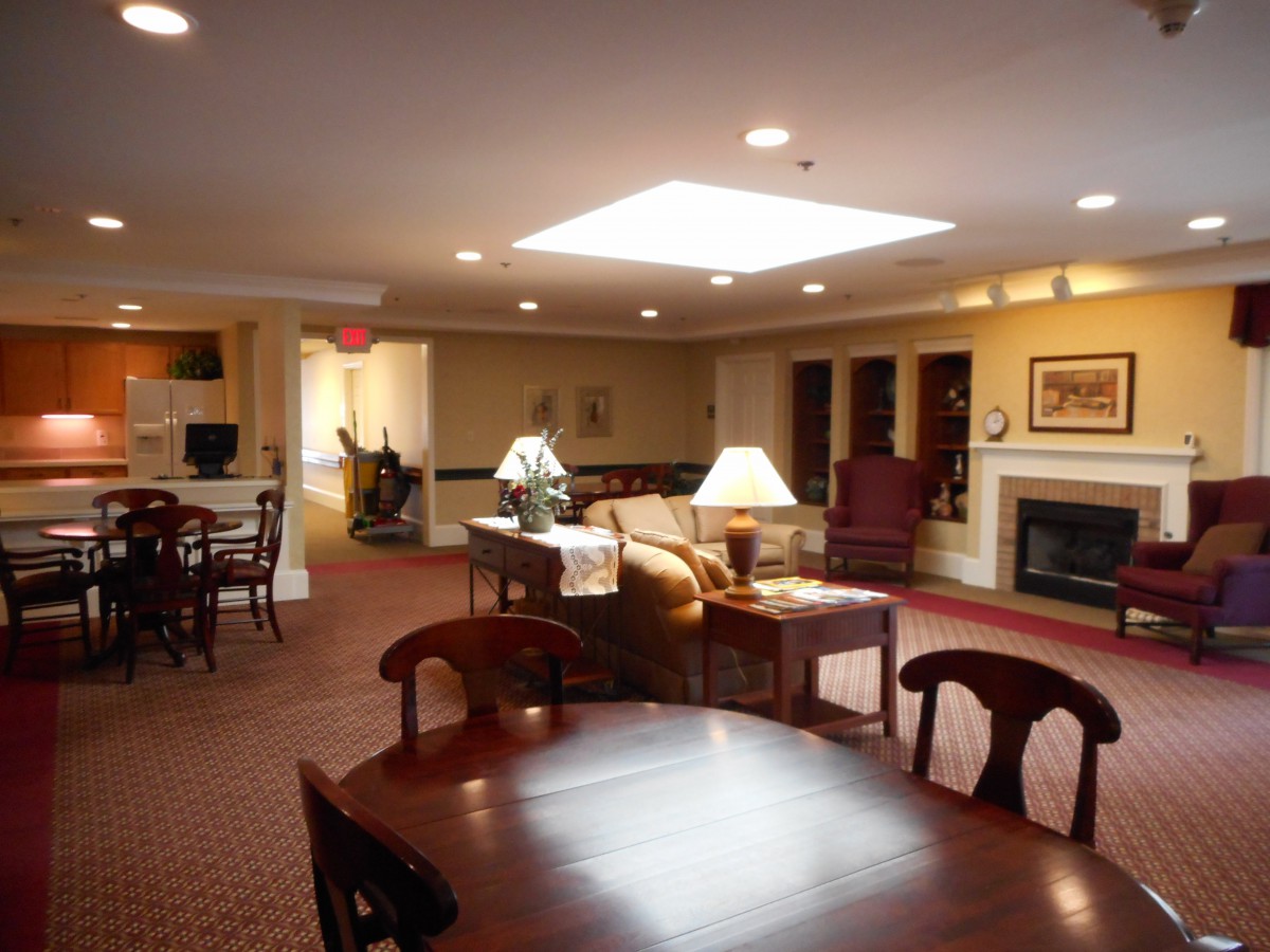 A cozy living room featuring comfortable seating, a fireplace, and elegant lighting.