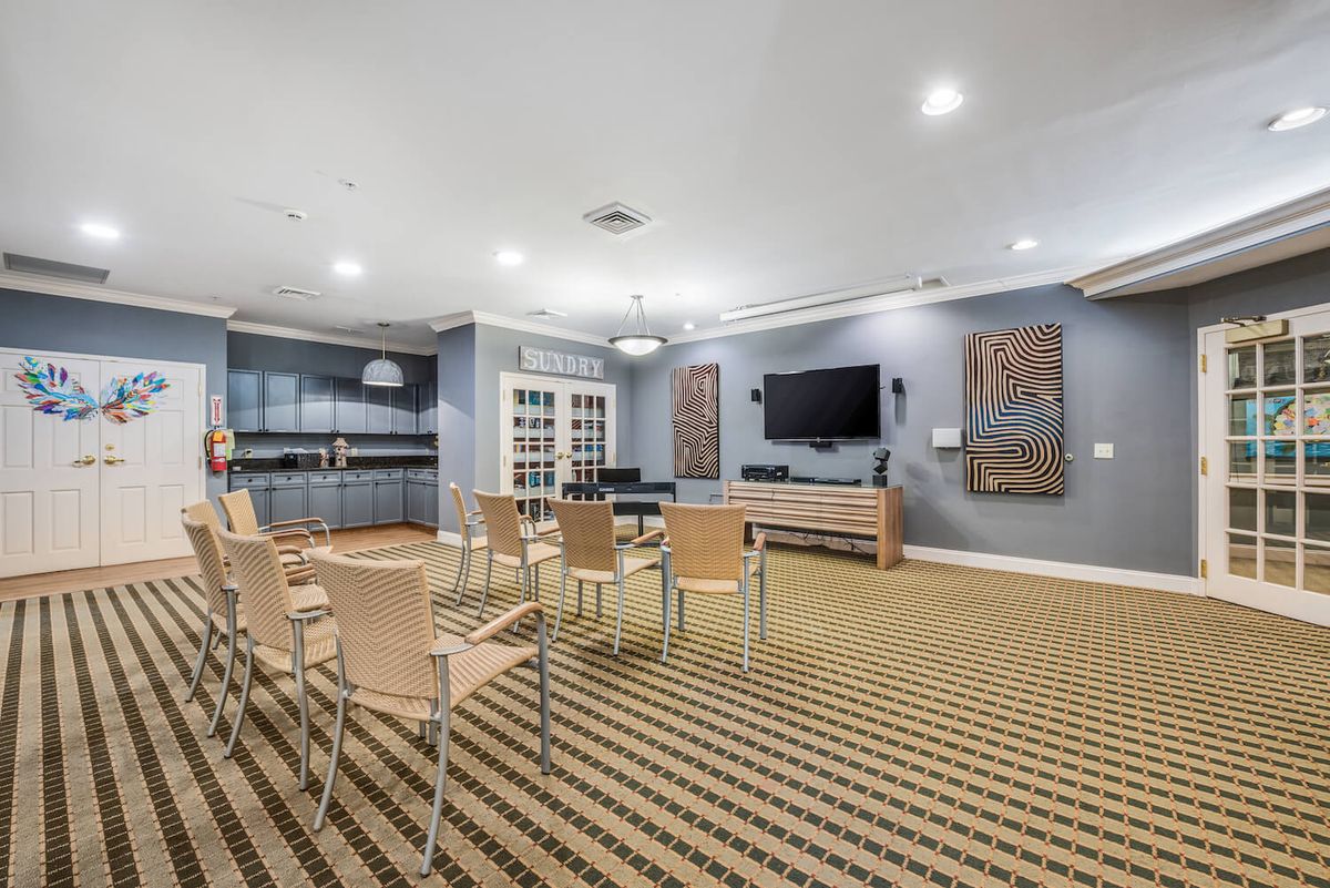 A modern conference room with arranged seating and a large television.