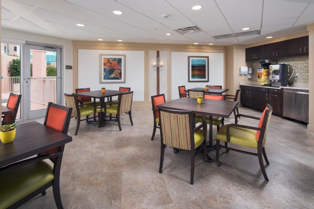 A modern dining area with neatly arranged tables and chairs, complemented by artwork on the walls.