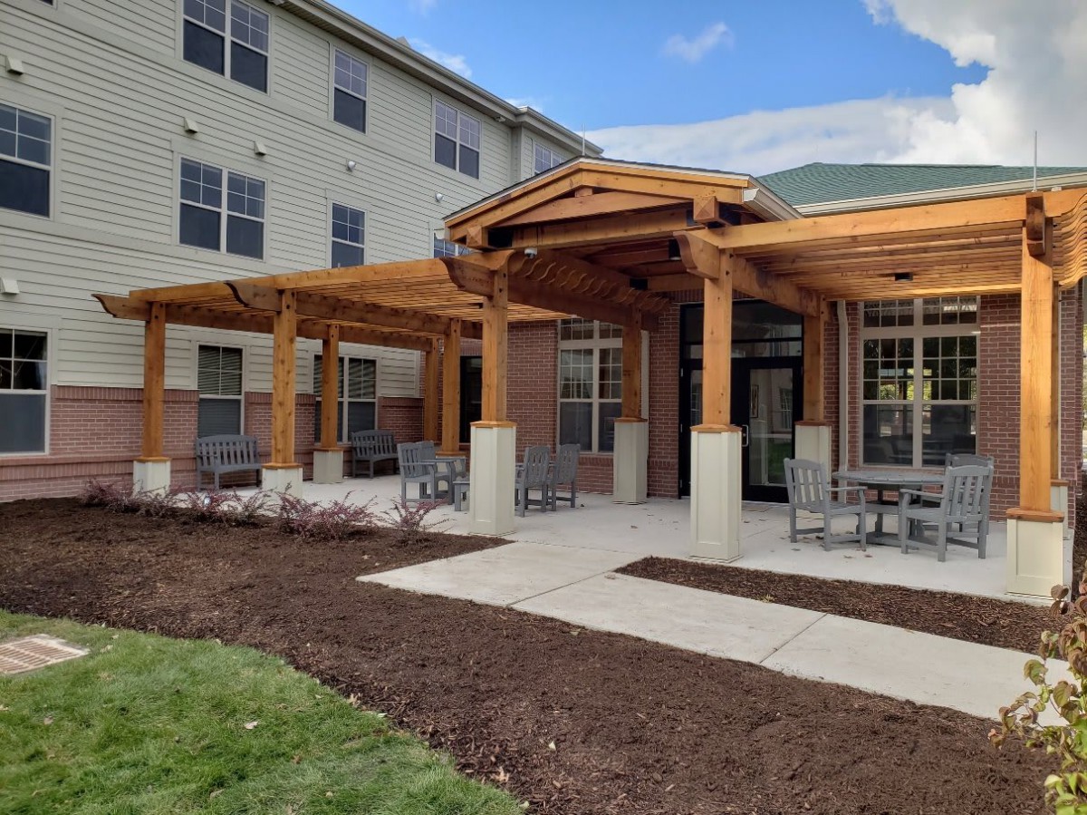 A modern building with a wooden patio and outdoor seating area.