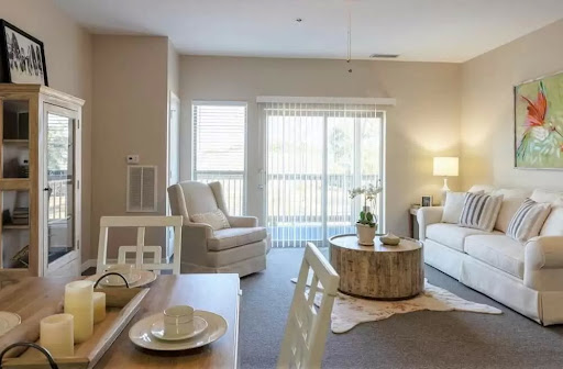 A cozy and modern living room featuring soft seating, a round coffee table, and ample natural light.