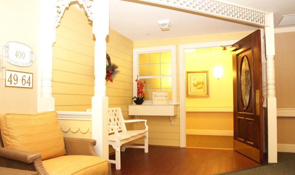 A cozy hallway with yellow walls and a white bench.