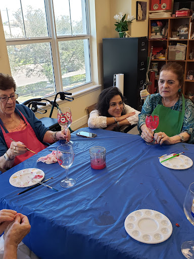 A group of women enjoying a creative activity at a table, surrounded by crafting materials.