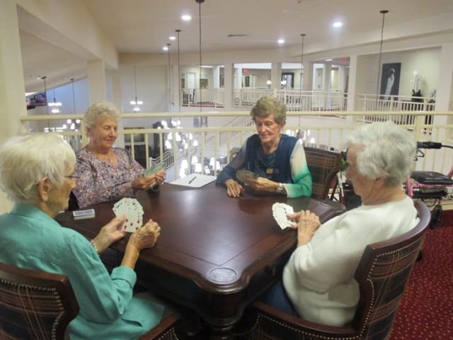A group of elderly women enjoying a card game together indoors.