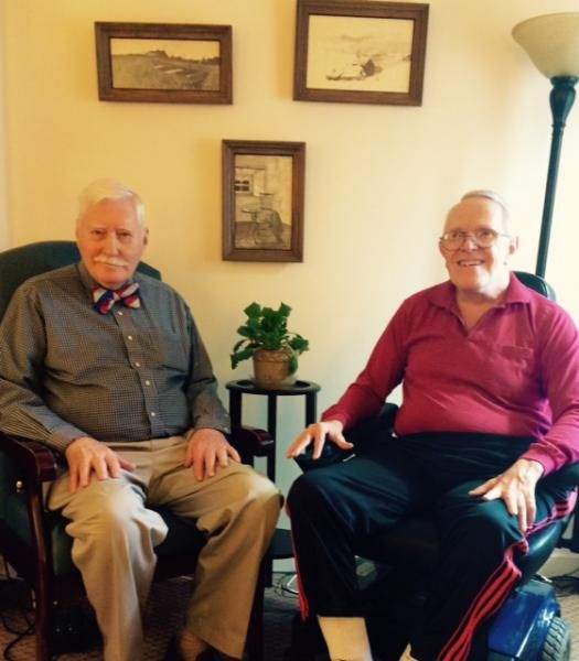 Two elderly men seated in a cozy living room setting.