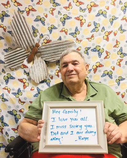 A heartfelt message to family from a smiling elderly person, captured against a colorful butterfly-patterned background.