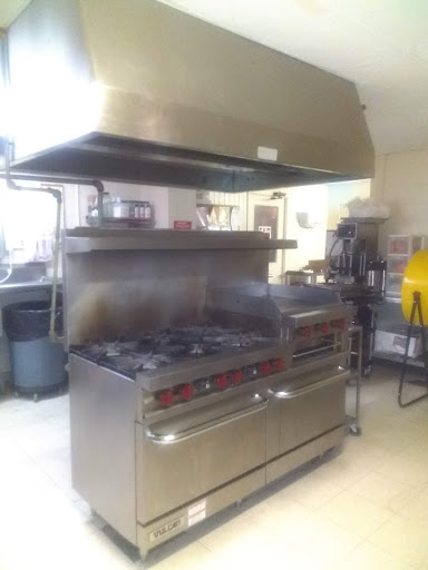A well-equipped commercial kitchen featuring a gas stove and exhaust hood.