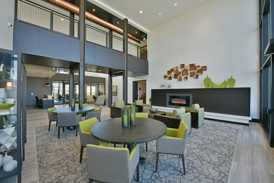 A modern lobby with stylish furniture and a fireplace.