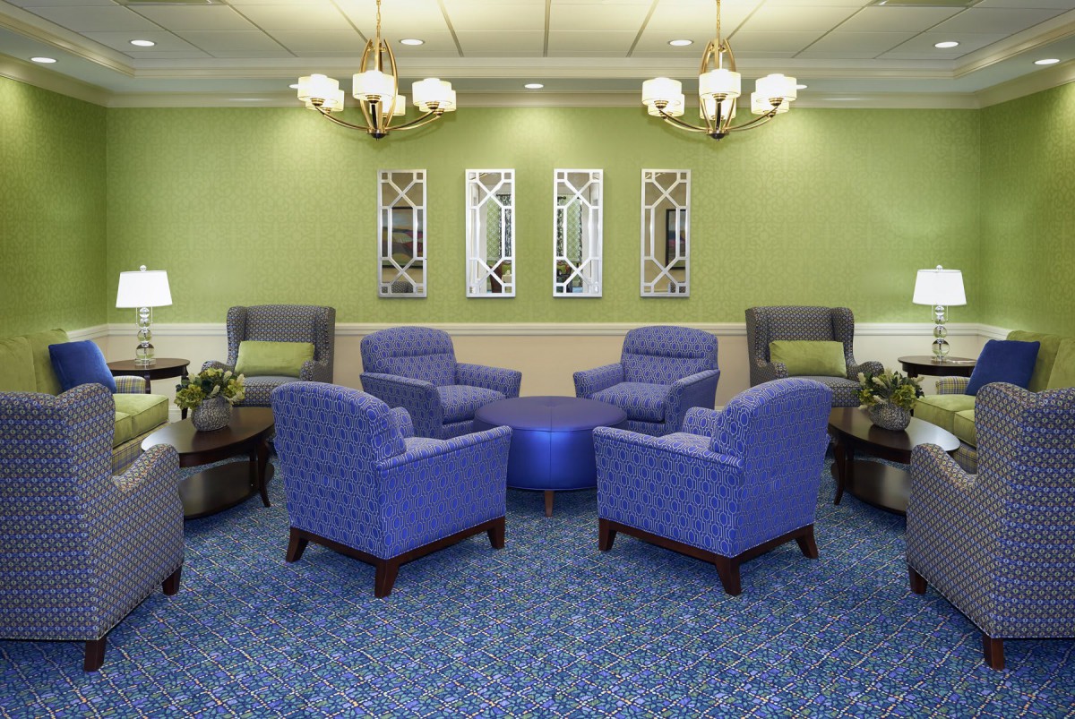 A stylish lounge area with blue chairs and green walls.