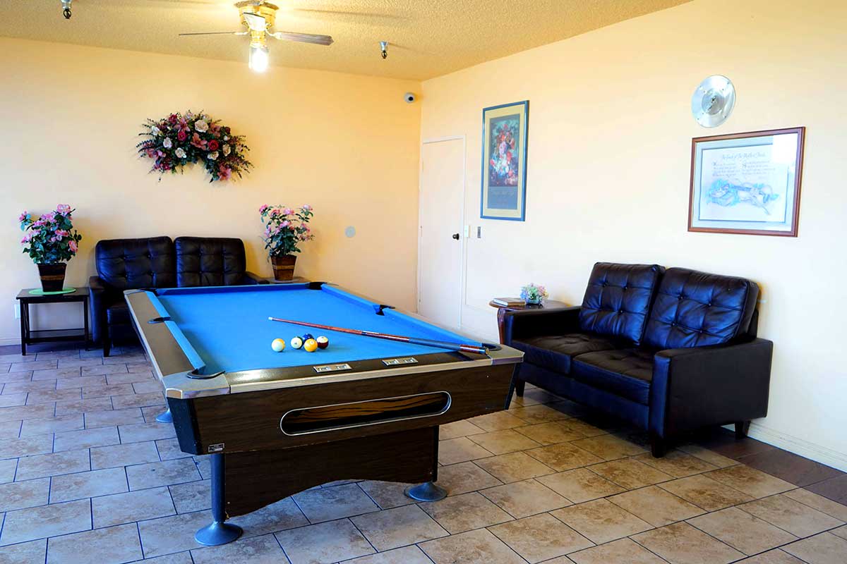 A cozy indoor space featuring a blue pool table and comfortable seating.