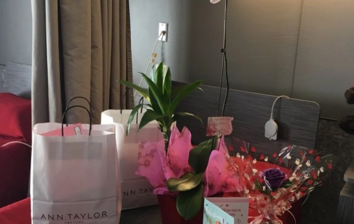 A hospital room with gift bags and flowers, creating a welcoming atmosphere.