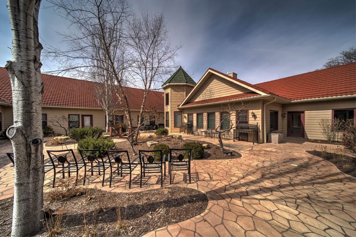 A serene courtyard featuring a stone path, seating area, and elegant architecture.