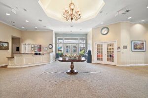 A spacious and elegantly designed lobby featuring a central chandelier and stylish furniture.
