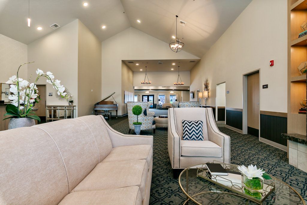 A modern living room with elegant furniture and a grand piano.