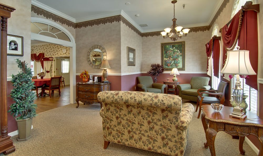 A traditionally decorated living room with floral-patterned furniture and warm lighting.