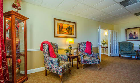 A cozy living room with floral armchairs and warm lighting.