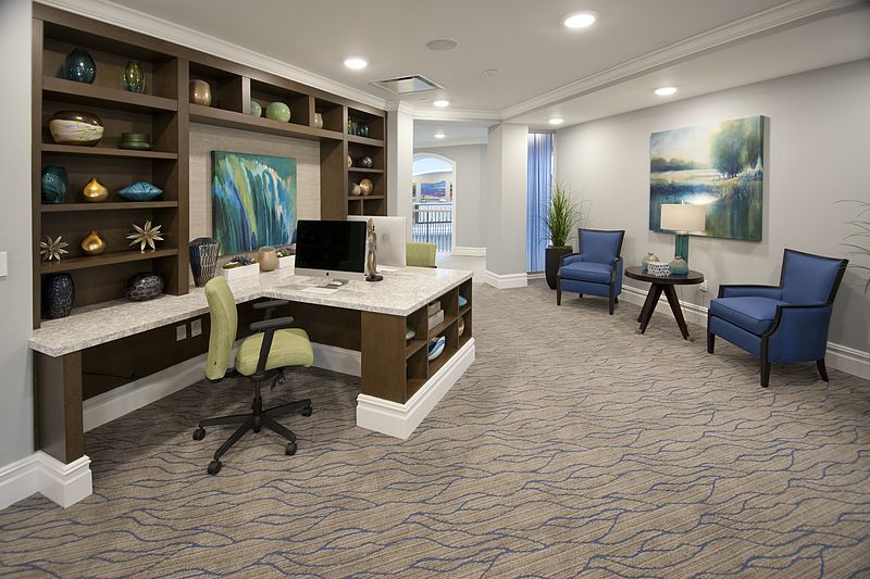 A modern office space featuring a desk, seating area, and stylish decor.