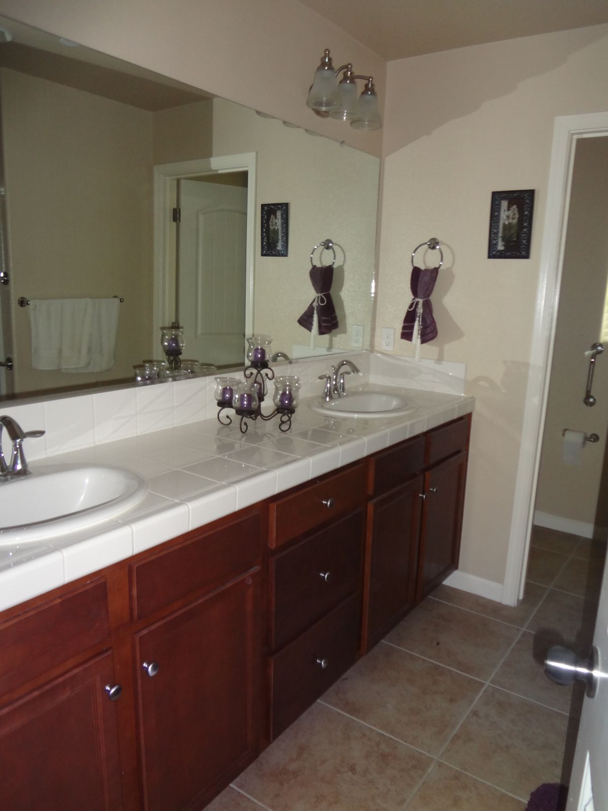 A modern bathroom with a double sink vanity and large mirror.