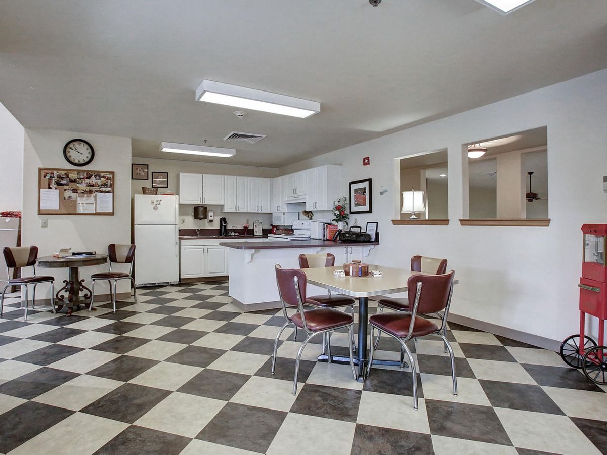 A retro-style kitchen with a checkered floor and vintage dining furniture.