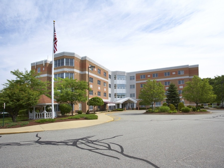 Exterior view of a hospital building with an American flag and surrounding greenery.