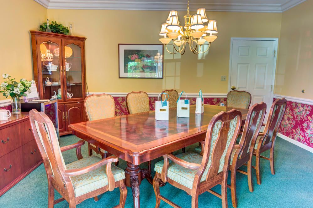 A well-decorated dining room with a wooden table, matching chairs, and a chandelier.