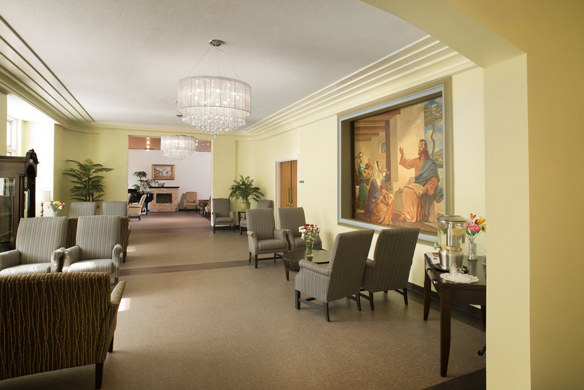 A spacious and well-decorated lobby with comfortable seating, a chandelier, and artwork on the wall.