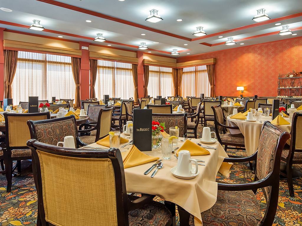 An elegantly set dining room with neatly arranged tables and chairs, ready for guests.