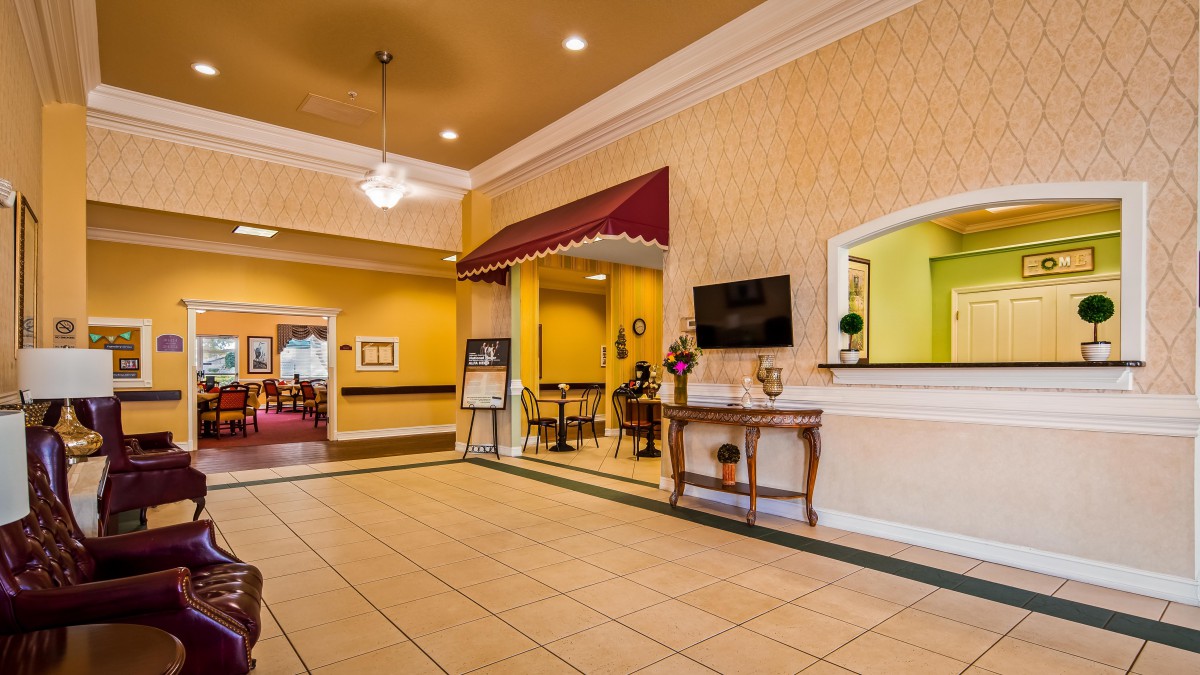 A welcoming hotel lobby with seating and a television.