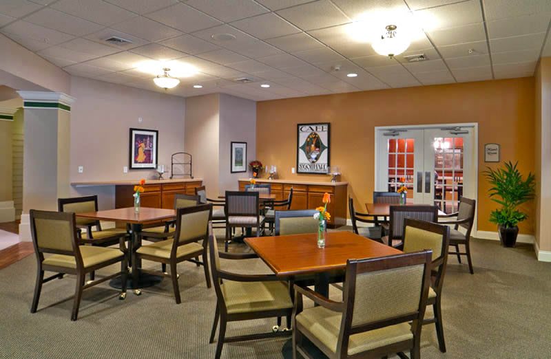 A modern and well-lit dining area featuring neatly arranged tables and chairs with contemporary decor.