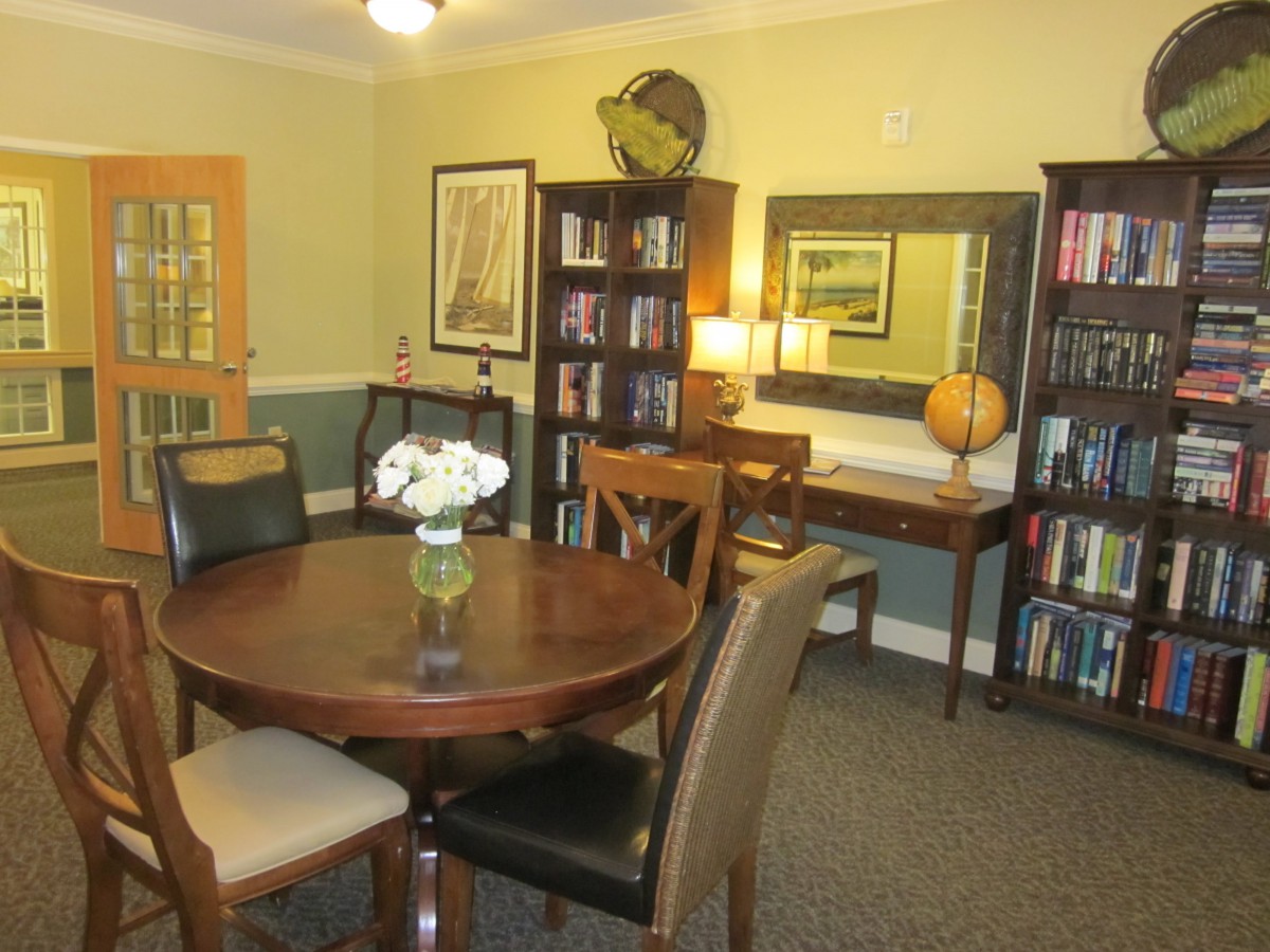 Cozy library room with a round table and bookshelves.