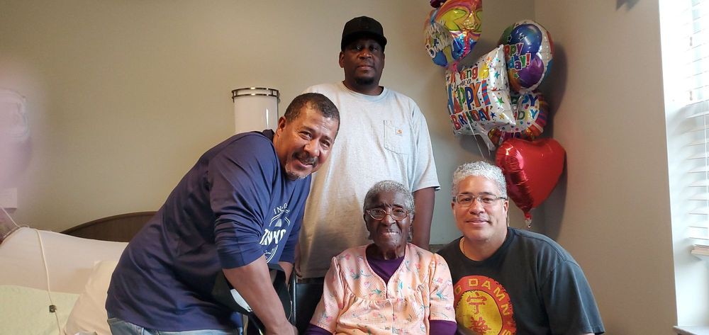 A family gathering with smiles and balloons, celebrating a special occasion.