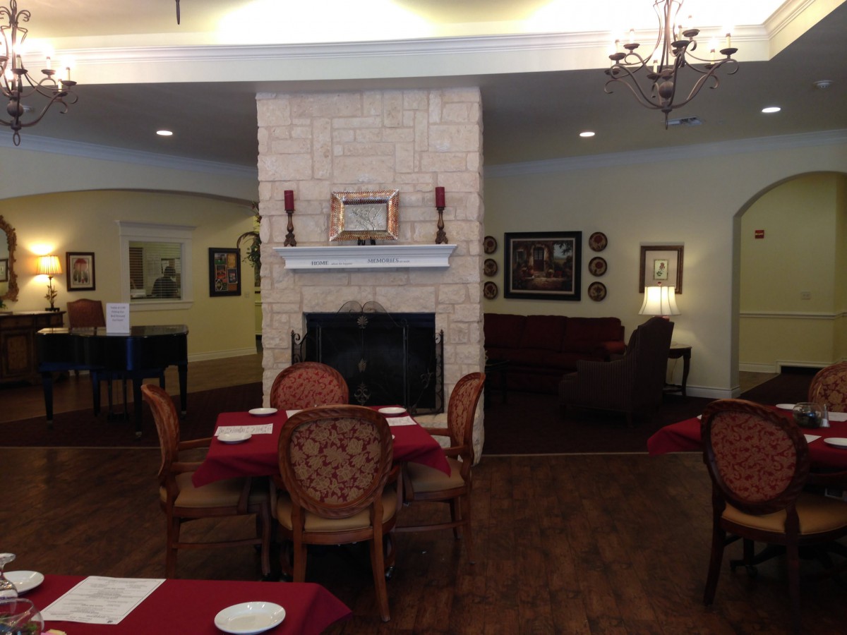 A cozy dining area featuring a central fireplace with elegant seating arrangements.