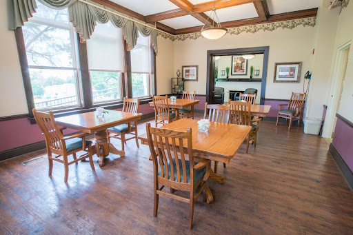 A well-lit dining room featuring wooden tables and chairs, creating a warm and inviting atmosphere.