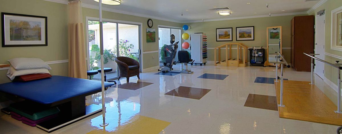 A bright and spacious lobby area with colorful floor tiles, chairs, and balloons by the window.