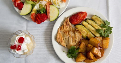 A delicious and healthy meal featuring grilled chicken with assorted vegetables and a fresh salad.