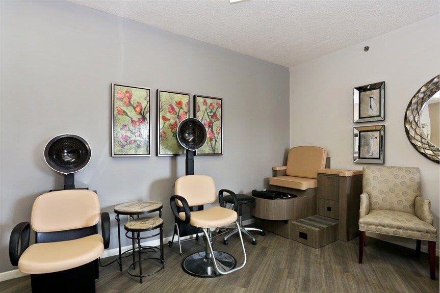A cozy salon interior with hair drying stations and decorative artwork.
