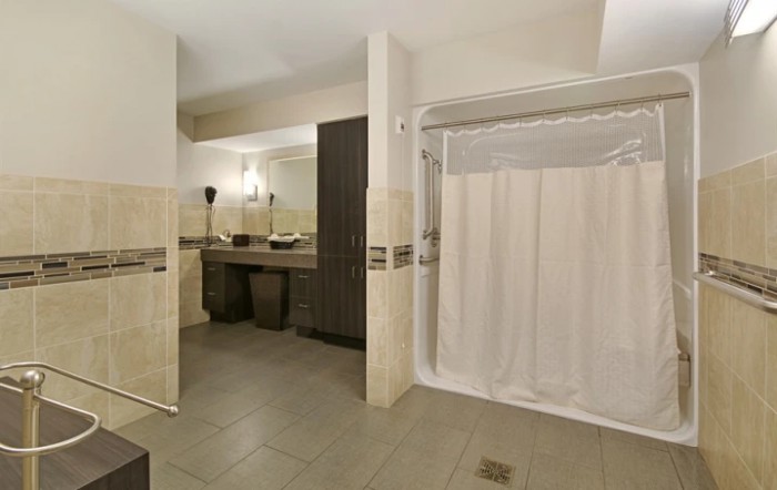 A modern bathroom with a double sink and a curtained shower area.